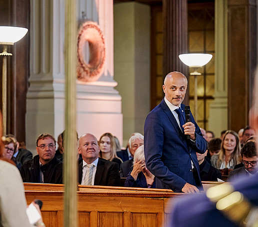 Prof. Maiwald steht und spricht ins Mikro.