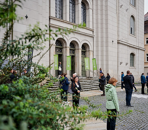 Menschen stehen vor dem Haupteingang der Johanniskriche.