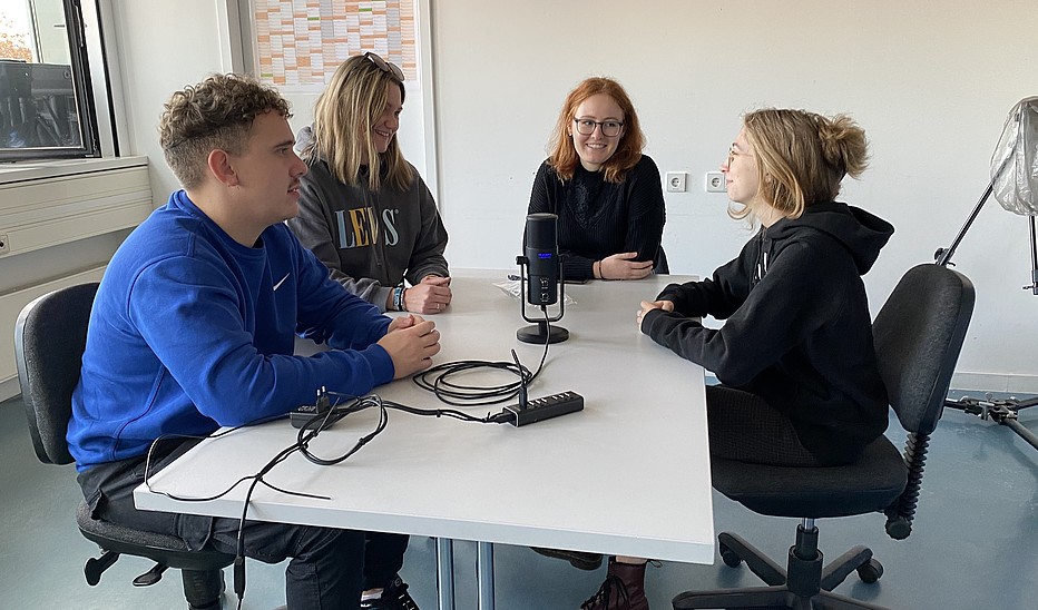 Foto: HSZG Eine Gruppe Studierender sitzt am Tisch und unterhält sich.