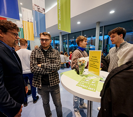 Studierende am Infotisch unterhalten sich mit Prof. Zips.