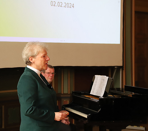 Ellen Leuschner vor dem Publikum, im Hintergrund Herr Leipert am Klavier.