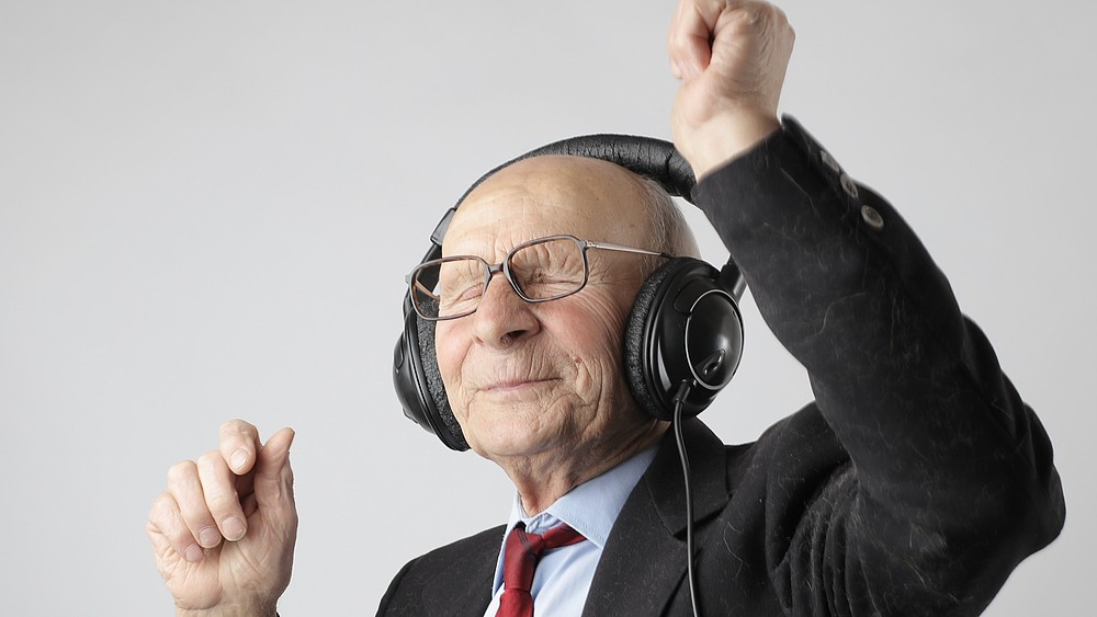 Glücklicher Senior mit Kopfhörern als Symbol für Master-Studiengang Soziale Gerontologie