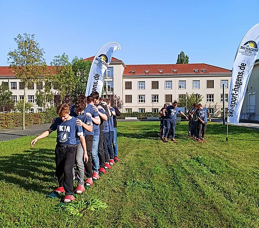 Studierende spielen auf einer Wiese auf dem Campus.