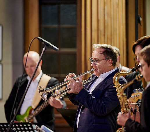 Trompeten- und Saxophonspieler spielen ins Mikro rein.