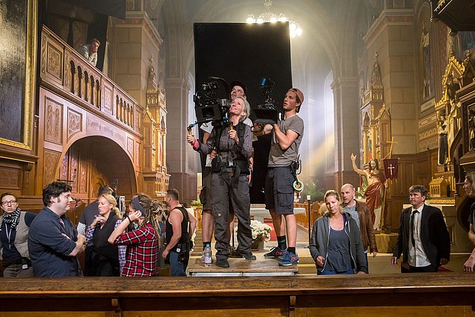 Ein Kamerateam filmt in einer Kirche.