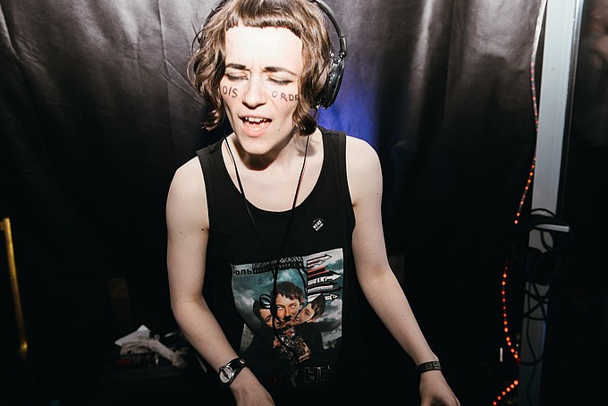 DJ Ludmila Pogodina am Musikpult mit Kopfhörern und geschlossenen Augen