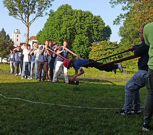 Studierende spielen auf einer Wiese auf dem Campus.