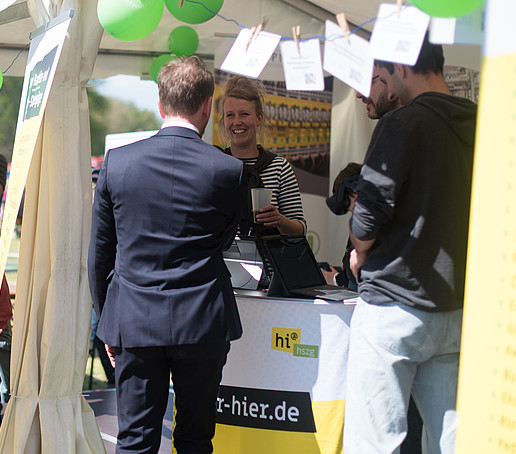 Der Ministerpräsident begrüßt eine Mitarbeiterin am HSZG-Stand.